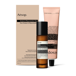 Un flaconcino di Solais Replenishing Hand Serum e un tubetto di Resurrection Aromatique Hand Balm, confezionati insieme in una scatola di cartone.
