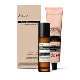 Un flaconcino di Solais Replenishing Hand Serum e un tubetto di Resurrection Aromatique Hand Balm, confezionati insieme in una scatola di cartone.