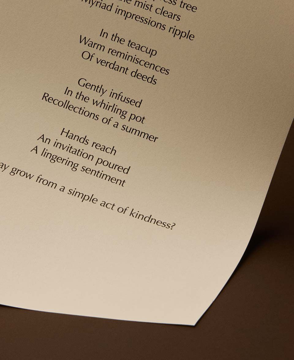 Versi poetici centrati su una pagina color crema ricurva, su uno sfondo marrone caldo.